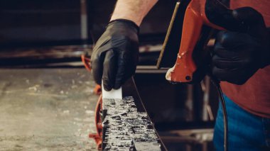 Kayak tabanına demirle sıcak mum sürüyorum. Kayak tabanına kayak cilası sürüyorum. Kayak zemini ayarlaması. Kayak demiri ve balmumu çubukları. Kayak servisi ve onarım. Atölye kayak servisinde tamirci. Atölyede Kayak Yapan Adam