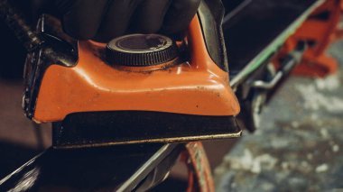 Kayak tabanına demirle sıcak mum sürüyorum. Kayak tabanına kayak cilası sürüyorum. Kayak zemini ayarlaması. Kayak demiri ve balmumu çubukları. Kayak servisi ve onarım. Atölye kayak servisinde tamirci. Atölyede Kayak Yapan Adam