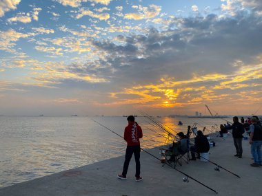 İstanbul Marmara Denizi kıyılarında 28 Ekim 2019 'da gün batımında balık tutan balıkçılar