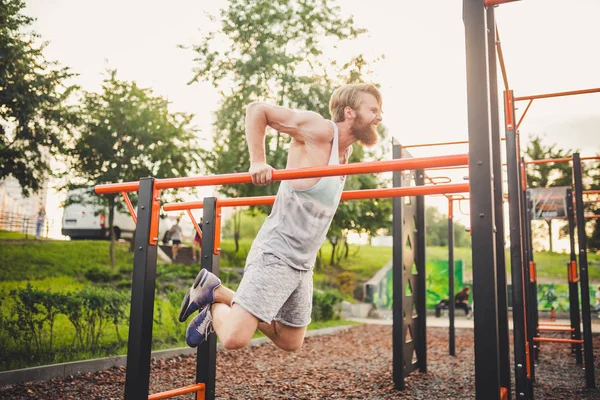 Fit Man Workout Arms On Dips Horyzontalne sztangi Trening triceps and Biceps Robi Push Ups. Przystojniak ćwiczy na równoległych sztabkach. mężczyzna sportowiec ćwiczenia na równoległe bary na świeżym powietrzu — Zdjęcie stockowe