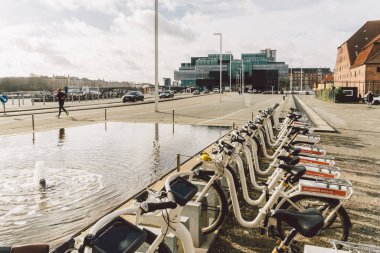 20 Şubat 2019 'da Danimarka' nın merkezindeki Kopenhag 'da kiralık elektrik bisikletleri. Şehir merkezindeki caddede bisiklet kiralama yeri. Şehir caddesinde park edilmiş birçok bisiklet kiralık.