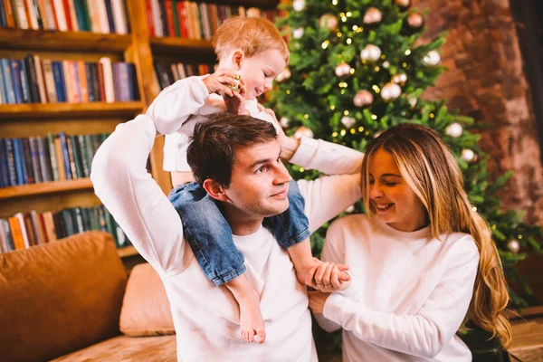 Family Christmas Concept. Lovely family sits near Christmas tree on winter evening. Happy family with son on floor near sofa At home. Family At Home At New Year Time. family enjoy new year holidays — Stock Photo, Image