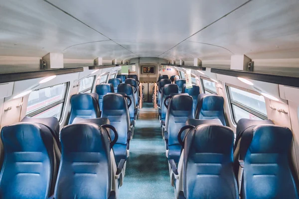 Interior of railway passenger car of the second class in train in Lombardy in Italy. Train interior. Blue seats in a commuter train. Interior of an Italian railway carriage. Empty without people — ストック写真