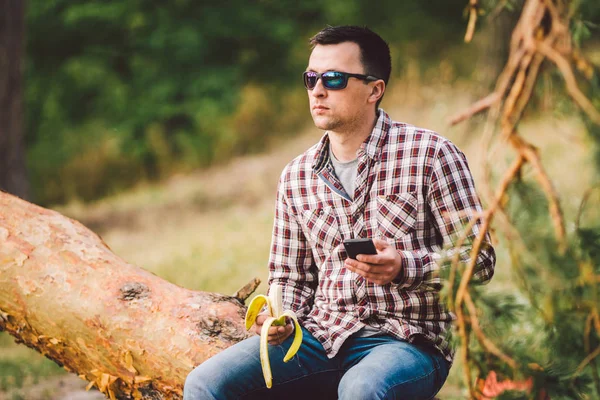 Eating banana Outdoors Hiking Trail. theme hiking and nature travel. Tourist take a rest and eating babanas. picnic in the forest. tourist eat snack food. Vitamin charge — Stock Photo, Image