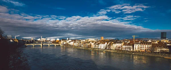 Basel şehri ve Rhine nehrinin manzarası. Miras, güzel. Kışın güneşli havalarda İsviçre şehri Basel. Ren seti manzarası ve insanların yürüyüp rahatladığı nehir manzarası.