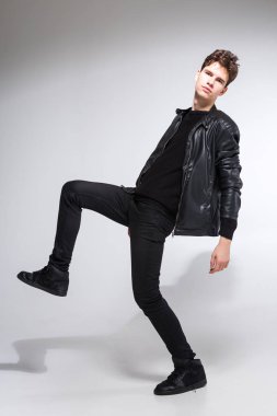 Beyaz arka planda koyu renk elbiseli genç adam portresi. Genç Erkek Moda Moda Model Pozisyonu. Siyah ceketli çekici genç manken.