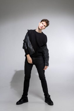 Beyaz arka planda koyu renk elbiseli genç adam portresi. Genç Erkek Moda Moda Model Pozisyonu. Siyah ceketli çekici genç manken.