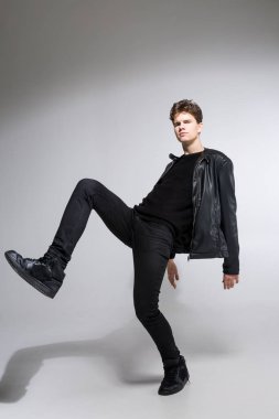 Beyaz arka planda koyu renk elbiseli genç adam portresi. Genç Erkek Moda Moda Model Pozisyonu. Siyah ceketli çekici genç manken.