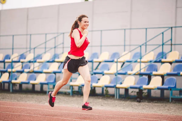 Žena běhající na stadionu. Mladá žena běhající na stadionu. Koncept dosažení cíle. Fitness Jogging Cvičení na hřišti. Wellness téma. Sportovní trénink kardio pro hubnutí úspěch — Stock fotografie