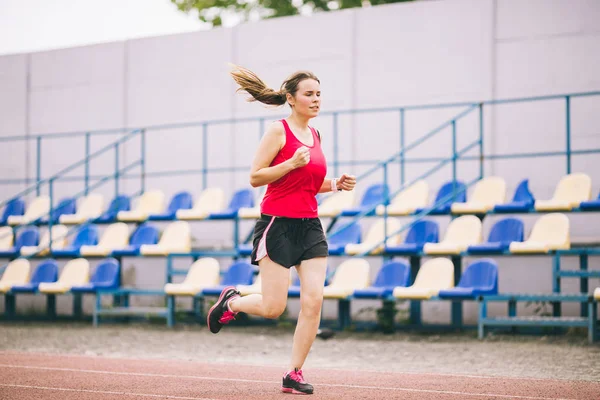 Stadyumda Koşan Kadın. Stadyum pistinde koşan genç bir kadın. Gol başarı konsepti. Spor sahasında spor koşusu. Sağlık teması. Kilo verme başarısı için spor antrenmanı kardiyosu — Stok fotoğraf