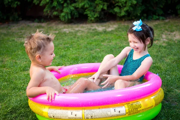 裏庭のプールで楽しいパーティーをしている子供たち。面白い子供たちは屋外プールで入浴。幸せな子供たちは水で遊んでいる。ガーデンパドリングプールで楽しい赤ちゃん — ストック写真
