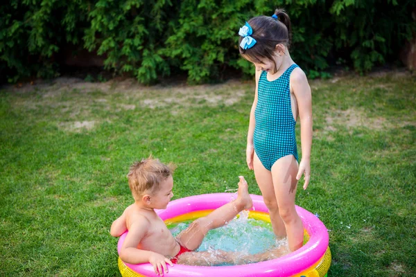 Kinder haben Spaß beim Party-Schwimmen im Hinterhof-Pool. Lustige Kinder beim Baden im Freibad. glückliche Kinder, die im Wasser spielen. Babys haben Spaß im Garten Planschbecken — Stockfoto