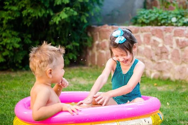 Kinder haben Spaß beim Party-Schwimmen im Hinterhof-Pool. Lustige Kinder beim Baden im Freibad. glückliche Kinder, die im Wasser spielen. Babys haben Spaß im Garten Planschbecken — Stockfoto