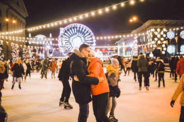 Aşık çift. Sevgililer Günü için Romantik Karakterler. Gerçek aşk. Mutlu çift akşam şehir buz pateni pistinde eğleniyor. Mutlu romantik çift buz pateni pistinde eğleniyor.