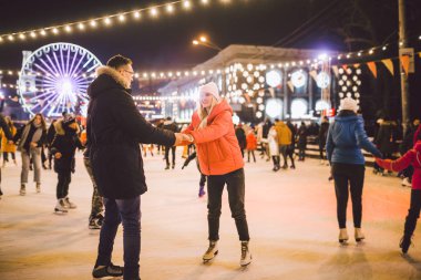 Aşık çift. Sevgililer Günü için Romantik Karakterler. Gerçek aşk. Mutlu çift akşam şehir buz pateni pistinde eğleniyor. Mutlu romantik çift buz pateni pistinde eğleniyor.