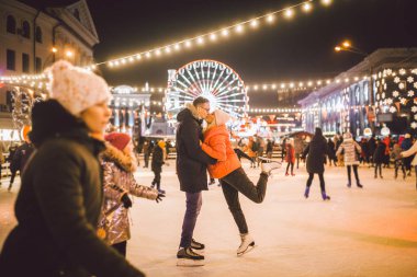 Aşık çift. Sevgililer Günü için Romantik Karakterler. Gerçek aşk. Mutlu çift akşam şehir buz pateni pistinde eğleniyor. Mutlu romantik çift buz pateni pistinde eğleniyor.