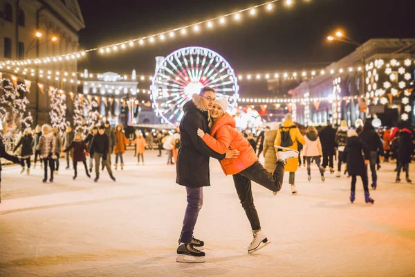 Gyönyörű pár korcsolyázás a városközpontban. Fiatal pár korcsolyázik egy nyilvános korcsolyapályán. Téma korcsolyapálya és szerető pár. Csodálatos téli szünet. Szent Valentin-nap — Stock Fotó