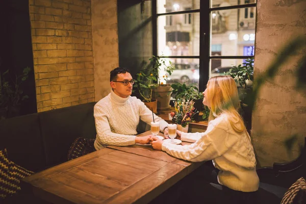 Mutlu çiftler buluşmaları ve kahve içmeleri. Aşk ve romantik randevu şehir merkezindeki kafe restoranda. Kafede aşık genç ve mutlu bir çift. Genç çift kafede buluşuyor, Noel zamanı konuşuyor ve öpüşüyor. — Stok fotoğraf