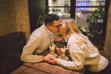 Randevuda kahve içen, birlikte eğlenen güzel bir çift. Modern kafeteryada kahve içen iki genç insan. Kafe 'de dinlenen bir çift. Sevgililer Günü 'nde bir çift sevgililer gününde kafede buluşuyor.