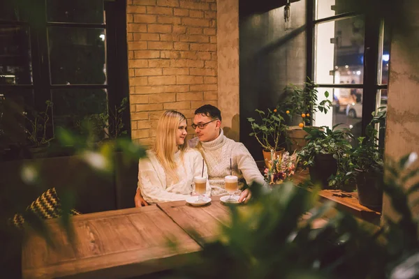 Encontro de casal feliz e beber café. amor e data romântica no centro do restaurante café. Jovem casal feliz apaixonado no café. Encontro jovem casal no café, conversando e beijando na época do Natal — Fotografia de Stock