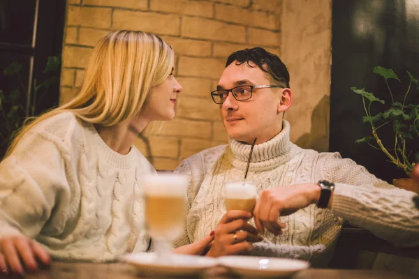 Jovem casal feliz apaixonado no café, homem e mulher juntos sorriem abraçando, bebendo café. Casal falando no café no inverno. Casal feliz desfrutando de um café na cafeteria. Felicidade, Natal — Fotografia de Stock