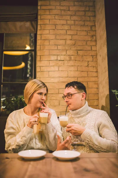 Beautiful couple having coffee on a date,having fun together. Couple young people drinking coffee in stylish modern cafeteria. Couple Resting in Cafe. Couple in love on date in cafe in Valentines day