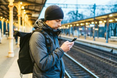 Sopot, Polonya, Avrupa 'daki tren istasyonu. Tren istasyonunda çekici bir adam bekliyor. Sırt çantasıyla gezmeyi düşünüyorum. Seyahat fotoğrafçılığı. Sırt çantalı turist tren istasyonunda duruyor.