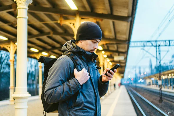 Train Station in Sopot, Poland, Europe. Attractive man waiting at the train station. Thinking about trip, with backpack. Travel photography. tourist with backpack stand on railway station platform