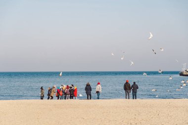 Polonya, Sopot, 9 Şubat 2020. Soğuk plajda koşan insanlar. Kuzeyli yürüyüşü. Deniz kenarında kış mevsimi. Sahilde Kış Yürüyüşü. İnsanlar soğuk mevsimlerde kıyıda rahatlar. Sopot plajında yürüyen kalabalık