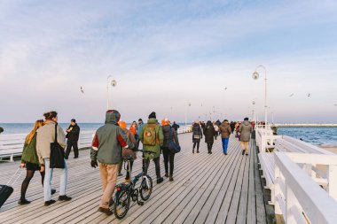 Sopot Pier Molo, 9 Şubat 2020 'de Polonya' nın Sopot şehrinde. Baltık Denizi 'nde bulunan Sopot' taki ünlü eski ahşap iskelede soğuk kış günü. İnsanlar Sopot 'ta Avrupa' nın en uzun tahta iskelesinde yürüyor..