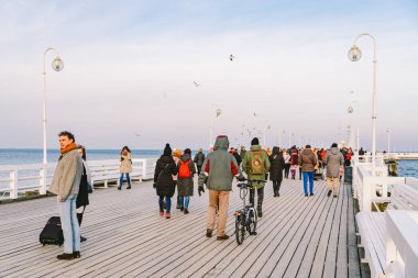 Sopot Pier Molo, 9 Şubat 2020 'de Polonya' nın Sopot şehrinde. Baltık Denizi 'nde bulunan Sopot' taki ünlü eski ahşap iskelede soğuk kış günü. İnsanlar Sopot 'ta Avrupa' nın en uzun tahta iskelesinde yürüyor..