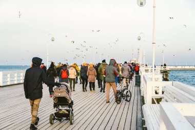 Sopot Pier Molo, 9 Şubat 2020 'de Polonya' nın Sopot şehrinde. Baltık Denizi 'nde bulunan Sopot' taki ünlü eski ahşap iskelede soğuk kış günü. İnsanlar Sopot 'ta Avrupa' nın en uzun tahta iskelesinde yürüyor..