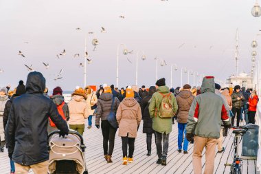 Baharda Sopot 'ta ahşap iskele. Güzel rüzgarlı hava. Sopot, Polonya 'daki eski ahşap iskelede kış günü. 9 Şubat 2020. İnsanlar Baltık Denizi yakınlarındaki güneşli kış gününde Sopot' taki ahşap iskelede yürüyorlar..