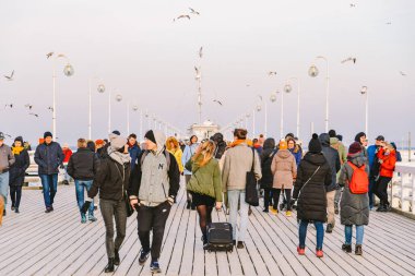 Sopot Pier Molo, 9 Şubat 2020 'de Polonya' nın Sopot şehrinde. Baltık Denizi 'nde bulunan Sopot' taki ünlü eski ahşap iskelede soğuk kış günü. İnsanlar Sopot 'ta Avrupa' nın en uzun tahta iskelesinde yürüyor..