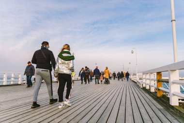 Sopot Pier Molo, 9 Şubat 2020 'de Polonya' nın Sopot şehrinde. Baltık Denizi 'nde bulunan Sopot' taki ünlü eski ahşap iskelede soğuk kış günü. İnsanlar Sopot 'ta Avrupa' nın en uzun tahta iskelesinde yürüyor..