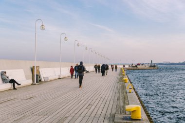 Sopot Pier Molo, 9 Şubat 2020 'de Polonya' nın Sopot şehrinde. Baltık Denizi 'nde bulunan Sopot' taki ünlü eski ahşap iskelede soğuk kış günü. İnsanlar Sopot 'ta Avrupa' nın en uzun tahta iskelesinde yürüyor..