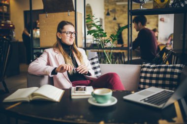 Kafede oturan güzel bir bayanın hayalindeki fikirler, yaratıcı bir meslek. temalı modern kadın blog yazarı. Elinde kalem olan genç bir kadın planlar üzerinde düşünüyor, birlikte çalışma alanında boş zaman yaratıyor..