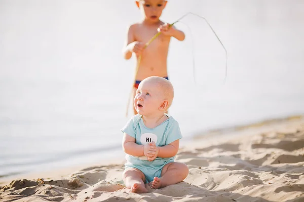 Lächelnder Kleiner Junge Sitzt Auf Dem Sand Der Nähe Des — Stockfoto