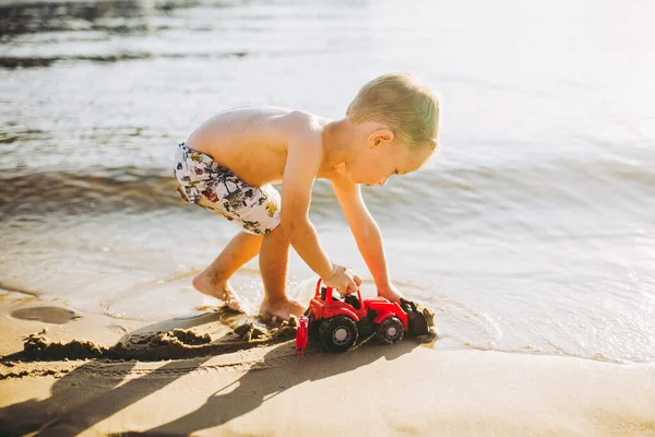 Niño Caucásico Juega Juguete Tractor Rojo Excavadora Playa Arena Junto —  Fotos de Stock