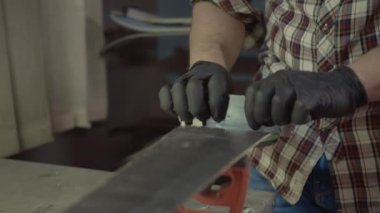 Kayak ustası. Kayak üssü plastik kazıyıcısından fazla mum çıkarıyorum. Kayak servisi ve onarım. Kış işçisi üs onarımı yapıyor. Kiralık atölye servisi. Atölye Kayak Servisi 'nde Tamirci