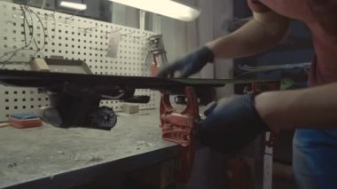 Güzel saç fırçasıyla kayak pistini temizliyorum. Tamirhanede fırçayla kayak yapan çekici bir işçi. Kayak ayarı ve bakım aracı. Fırçalama, balmumu temizleme, son kayak cilası. Kayağın tema onarımı
