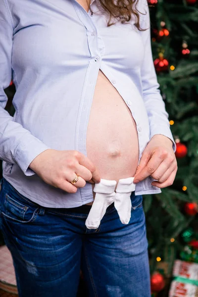 임신한 여자는 그녀의 이들의 크리스마스 옷에에서 하고있다 셔츠와 쓰레기 — 스톡 사진