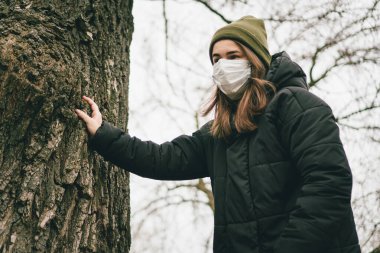 Tıbbi maske takan genç bir kadının portresi grip virüsünden korunma, salgın hastalık ve bulaşıcı hastalıklar. Sağlığınızı koruyun. Coronavirus konsepti. Virüs yayılmış grip önleme karantinası.