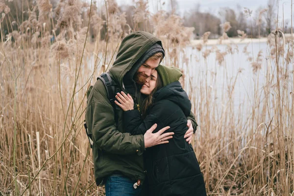 一对恋爱中的年轻的高加索夫妇站在湖边和芦苇旁拥抱 周末在大自然中散步 国内的户外运动 秋天的积极假期和徒步旅行 — 图库照片