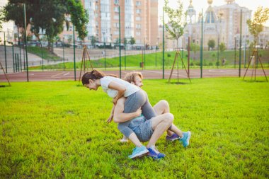 Şehirde zinde bir çift, eğleniyorlar, ara veriyorlar. Parkta antrenman yaparken mutlu çift portresi. Mutlu gülümseyen güzel bir spor çifti. Antrenmandan sonra dinleniyorum, güne birlikte başladığımız için mutluyum..
