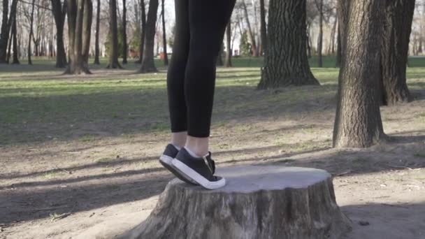 Stående kalvuppfödning. Närbild av benen sträcker. Sportig kvinna som värmer upp utomhus. Sträckande vadmuskler. hälsosam livsstil. Träning och övningar för musklerna i vaden ben i naturen i parken — Stockvideo
