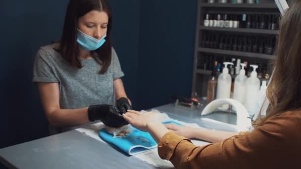 Salón de Spa. Manicura. Parafina baño de mano. proceso de tratamiento de parafina. Cuenco, aditivo. Cuidado de la bañera de cera. Cuidado de las uñas. Artista de uñas haciendo manicura. Maestro profesional que pone la manopla en la mano cliente — Vídeo de stock