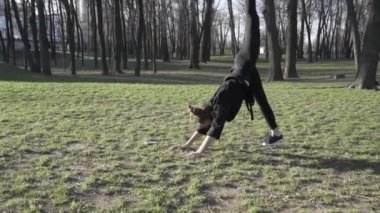 Parkta egzersiz yapan sağlıklı genç Asyalı kadın. Formda bir genç antrenman yapıyor. Sportif genç bayan ısınıyor, antrenmandan önce bacaklarını açıyor. WSportwoman Fitness Öncesi Esneme