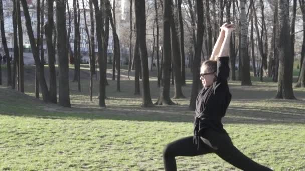 Dehnübungen. Sportlerin im Freien. Die fröhliche junge Sportlerin wärmt ihre Muskeln vor dem Training auf. Junge Frauen wärmen sich vor dem Fitnesstraining auf. Konzept eines gesunden Lebensstils — Stockvideo