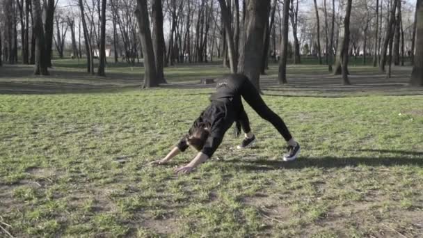 Egészséges, fiatal ázsiai nő tornázik a parkban. Alkalmas fiatalok edzenek. sportos fiatal nő bemelegítés, nyújtózkodó lábak edzés előtt szabadban. WSportwoman nyújtózkodás Fitness előtt — Stock videók